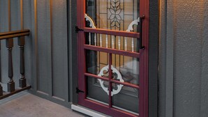 A wooden door with a glass panel and a decorative metal gate. - 𝗨𝗻𝗶𝗾𝘂𝗲 𝗦𝘁𝗮𝘆 at the Carriage Haus (Manitowoc)