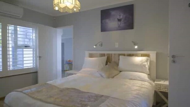 A bedroom with a large bed, a ceiling light fixture, and a wall-mounted picture. - Mount View. Luxury 3 bed villa with pool (Cape Town)