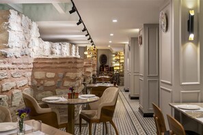 A restaurant with brick walls, round tables, and chairs. - Radisson Hotel Hagia Sophia a Member of Radisson Individuals (Istanbul)