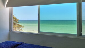 A room with a large window overlooking a beach. - Casa Mega - Yucatan Home Rentals (Chicxulub Puerto)