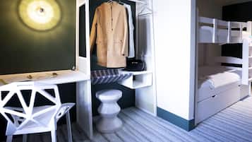 Habitación pequeña con una cama litera, un escritorio con silla, un perchero y un taburete.