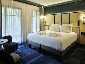 Una habitación de hotel con una cama grande, un escritorio y una silla.