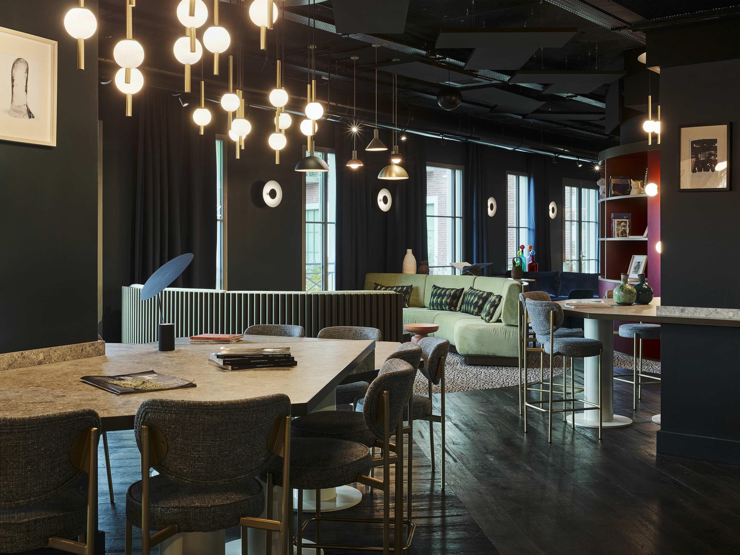 Un interior moderno con barra, asientos e iluminación colgante.