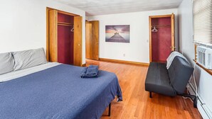 Een slaapkamer met een bed, een stoel en een kledingkast.