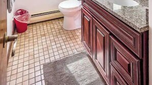 Een badkamer met toilet, wastafel en spiegel.