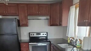 A kitchen with wooden cabinets, a black refrigerator, a stainless steel oven, and a sink. - 5⭐️BEST PRICE⭐️Robert's 3 Room for 2-7ppl Long term (Providence)