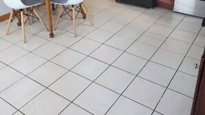 A kitchen with a dining table, chairs, a refrigerator, and an oven.