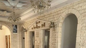 A spacious lobby with a tiled floor, stone walls, and a chandelier. - %ECONOMY APARTMENT% 101 (Amman)