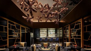 Een moderne lounge met banken, een bar en een hanglamp.