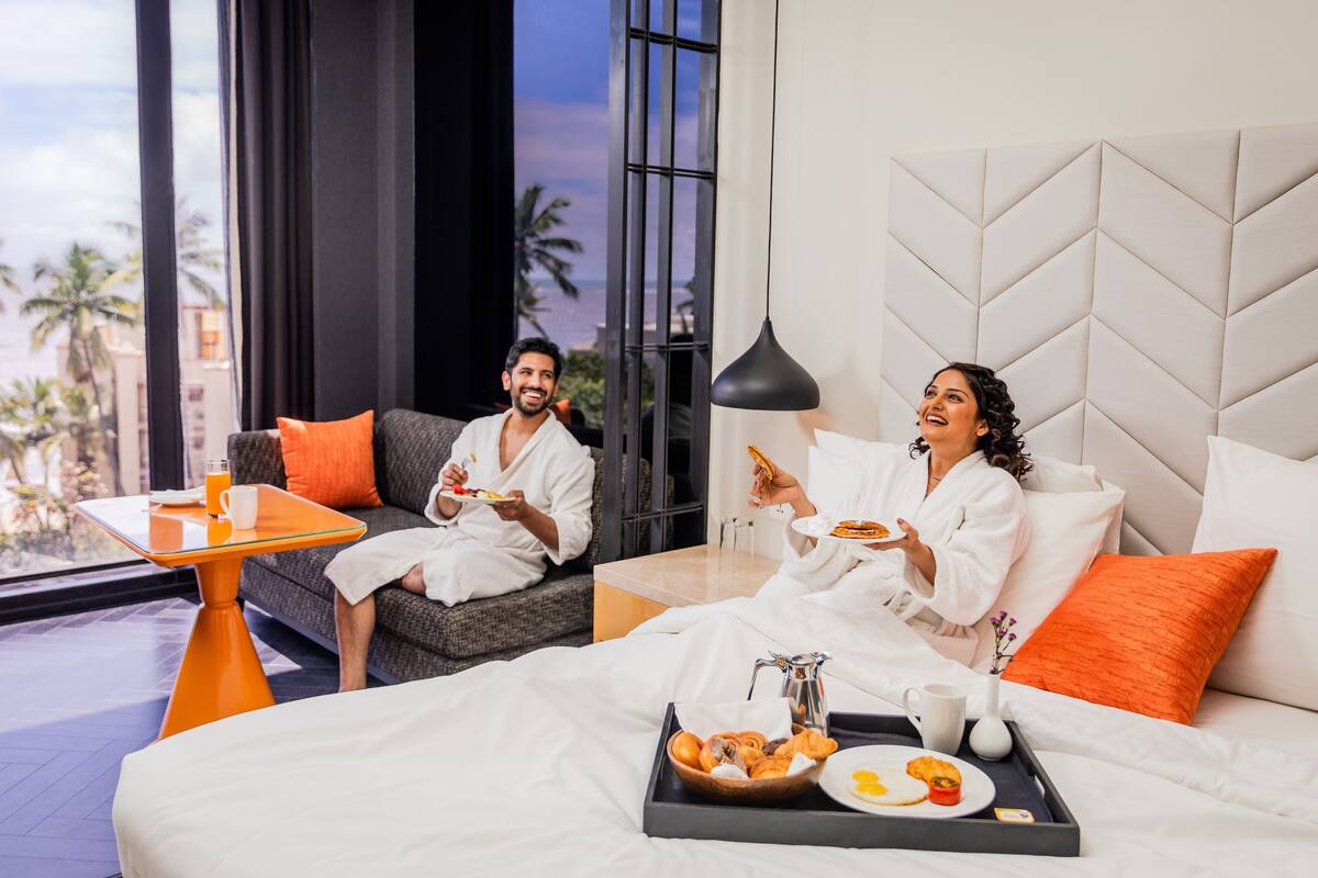 Ein Hotelzimmer mit Bett, einem kleinen Tisch und einem Tablett mit Frühstücksgebäck.