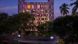 Een modern hotel met een geruit gevel, meerdere ramen en een bord dat het een Hyatt hotel aangeeft.