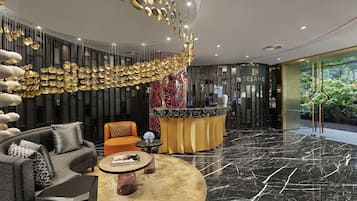 En moderne lobby med en buet receptionsdisk, en sofa og et sofabord.