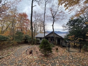 A cabin with a patio area surrounded by trees and a view of mountains. - Ski Chalet: 0.5 mi to slopes. Great view-Fireplace (Sugar Mountain)