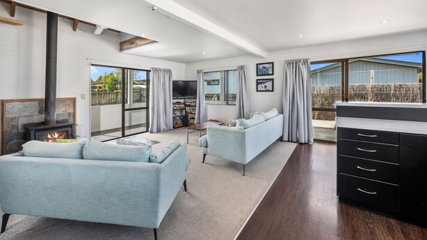 A spacious living room with a fireplace, two sofas, a TV, and a large window offering a view of the outside. - Sparkling 3-bedroom home with fireplace and views (National Park)