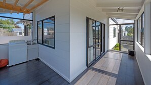 A modern kitchen with a washing machine, large windows, and a wooden ceiling. - Sparkling 3-bedroom home with fireplace and views (National Park)