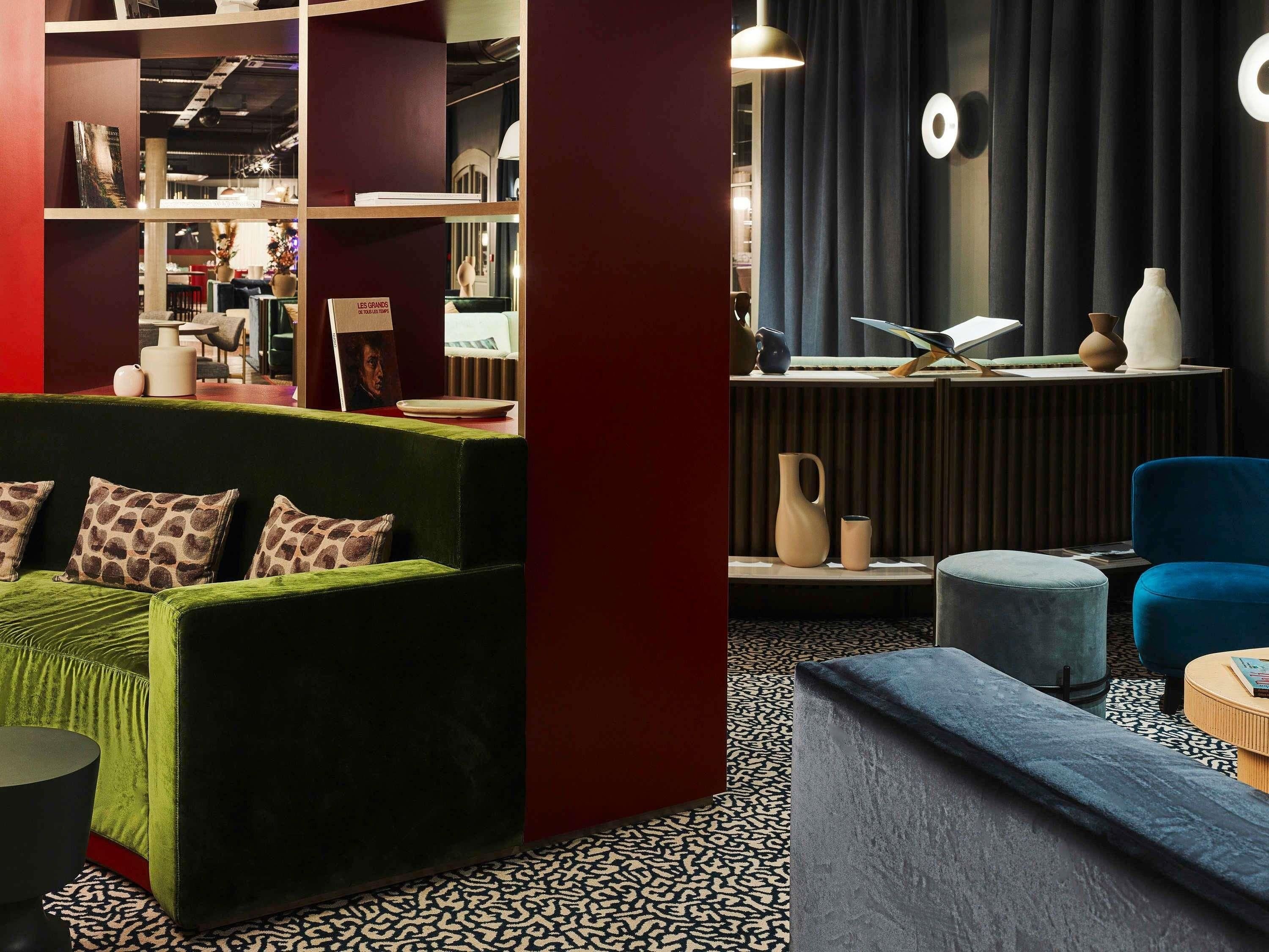 Een modern interieur met een groene bank, een blauwe stoel en een vloer met patroon.