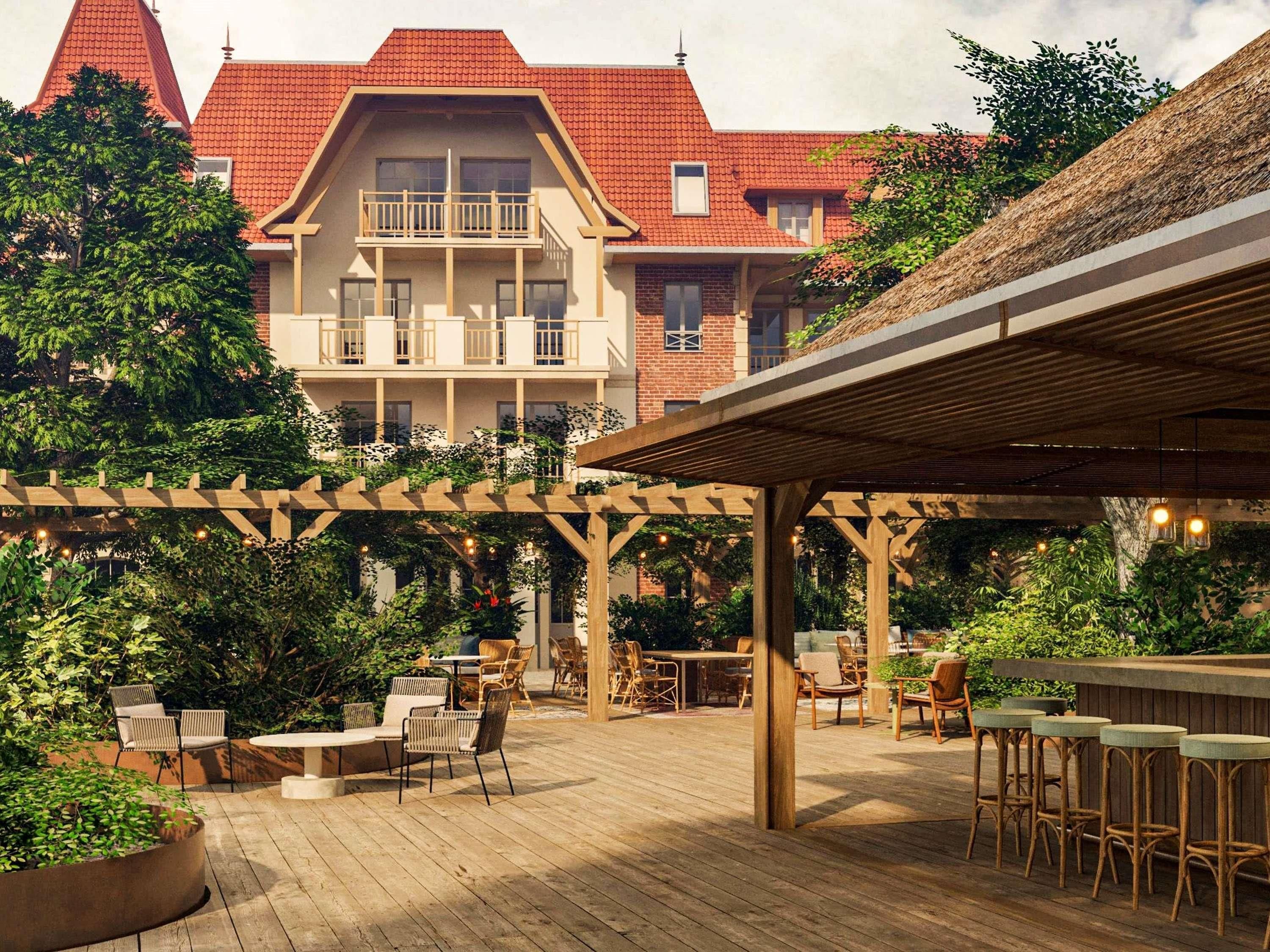 Une terrasse en bois avec des sièges extérieurs, une pergola et un espace bar.