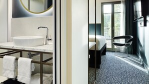 Ein modernes Badezimmer mit großem Spiegel, Waschbecken und Dusche.