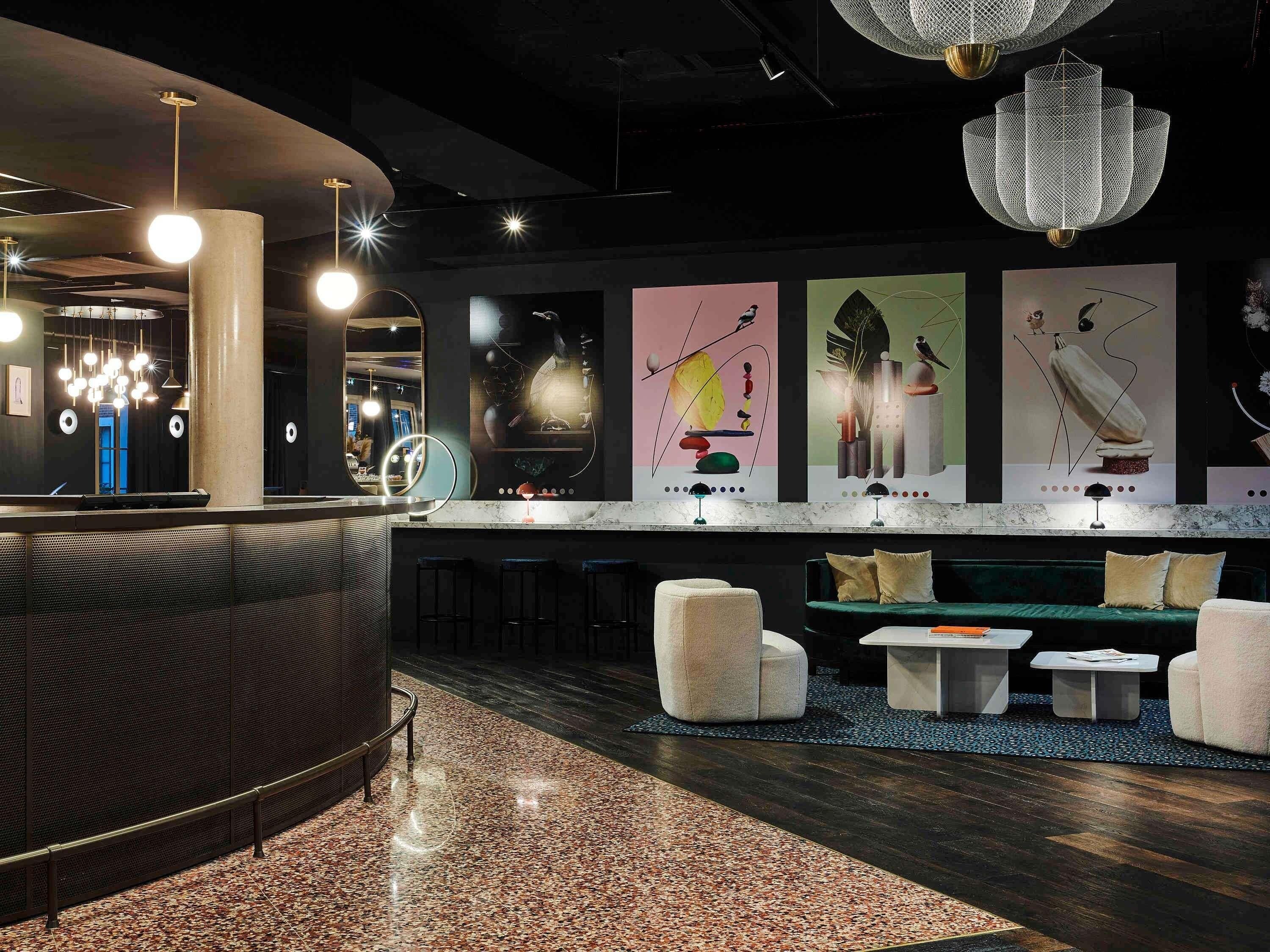 A modern bar area with a curved counter, seating, and abstract wall art.