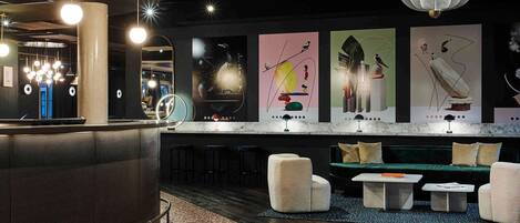 A modern bar area with a curved counter, seating, and abstract wall art.
