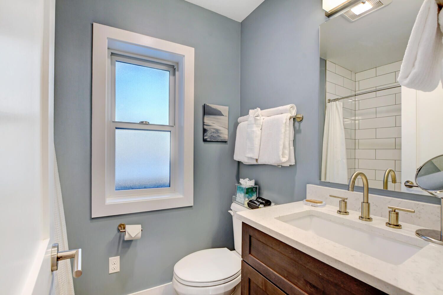 Un bagno con il water, un lavandino e una finestra.