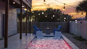 A backyard with a swimming pool, deck chairs, and string lights. - Spring Break Ready! Pool | Game Room | Sleeps 21 (Gulf Breeze)