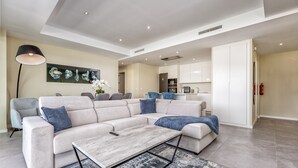 Ein modernes Wohnzimmer mit einem Ecksofa, einem Couchtisch und einer Stehlampe.