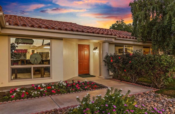 A residential house with a tiled roof, a front door, and a number "43622" on the wall.