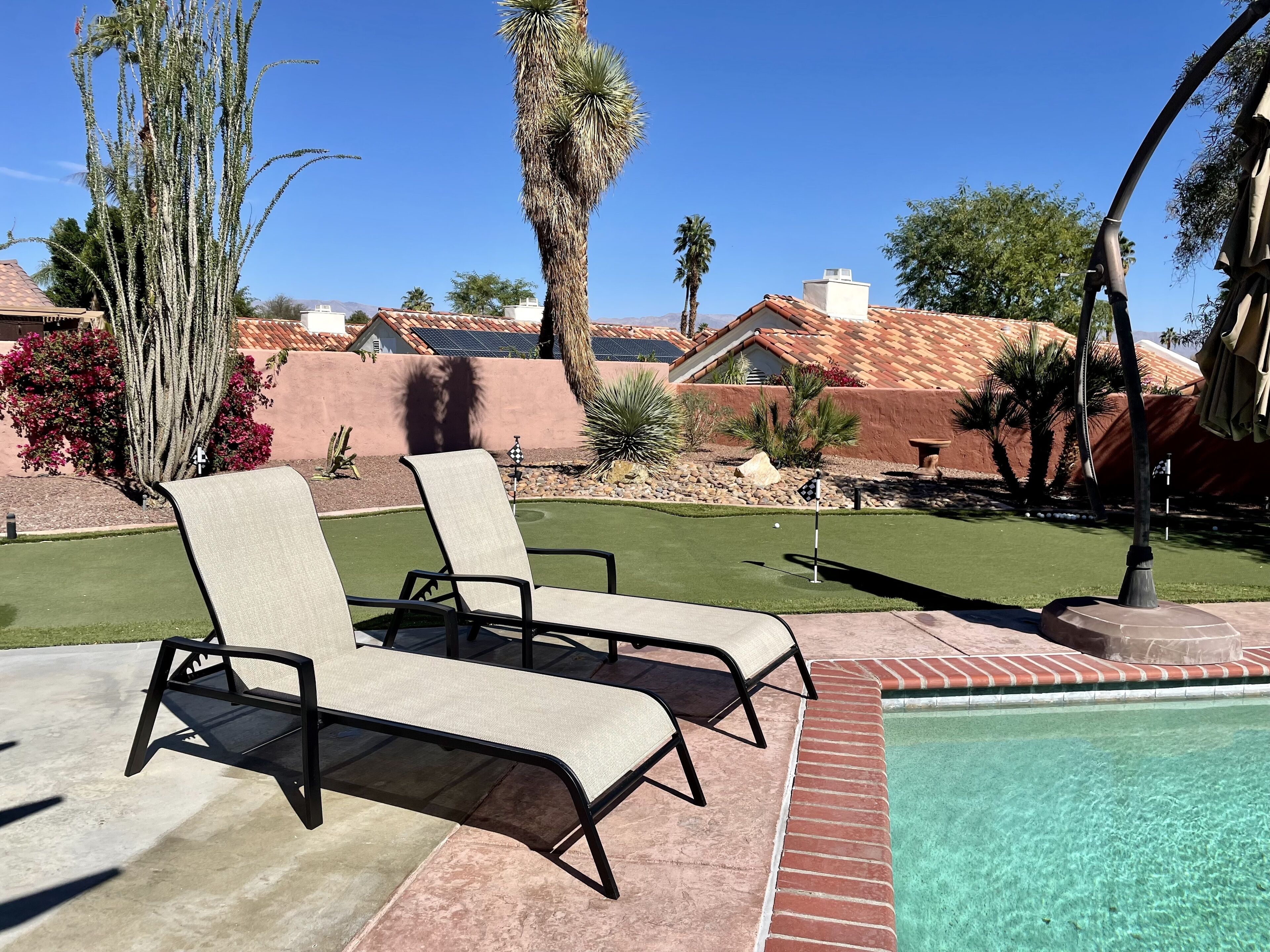 A poolside area with lounge chairs and a clear view of a pool.