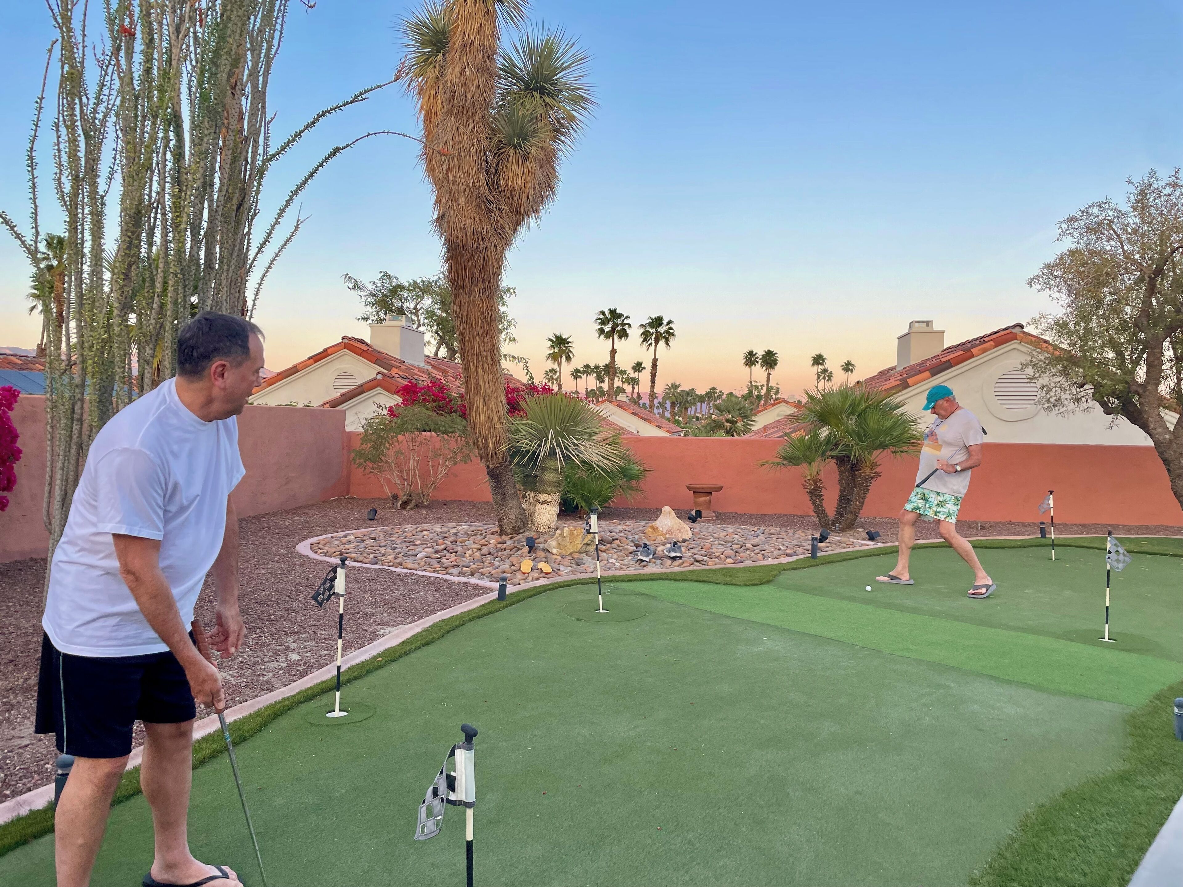 A golf course with a putting green, sand traps, and a flagstick.