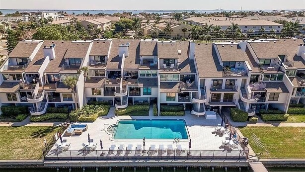 Een modern appartementencomplex met een centraal gelegen zwembad, balkons en uitzicht op de omliggende wijk.