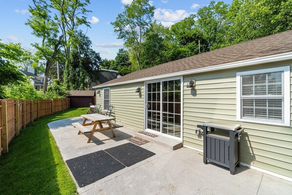 A single-story house with a patio, a wooden fence, and a garage.