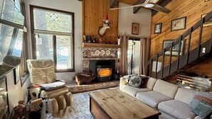 A cozy living room with a fireplace, a sofa, a massage chair, and a staircase. - Perfect Family & Dog Friendly 2 Story Condo, Sleeps 8+, 1 Mile To Village,  #66 (Mammoth Lakes)
