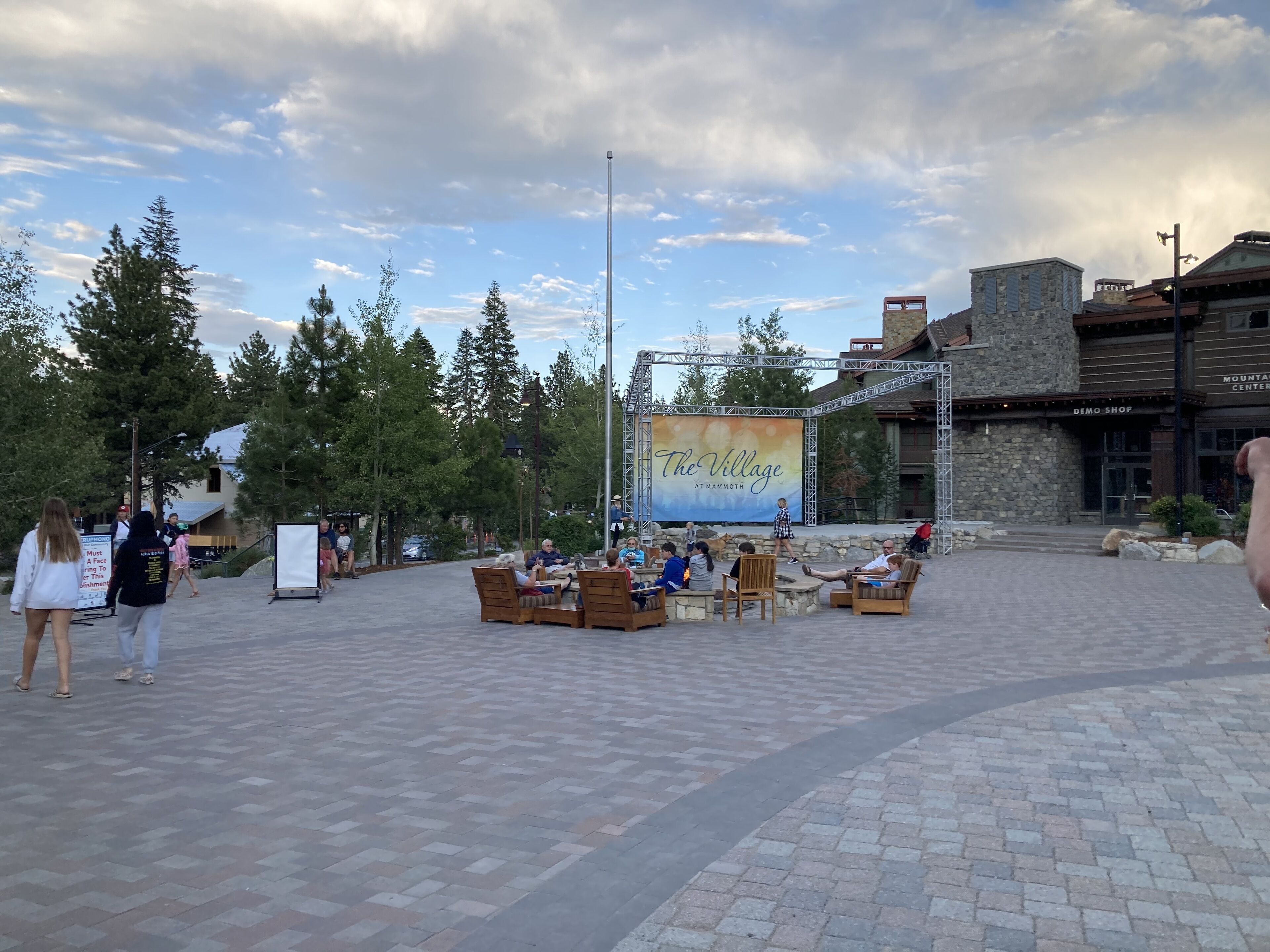 An outdoor seating area with a stage and a banner for 'The Village at Mammoth.'