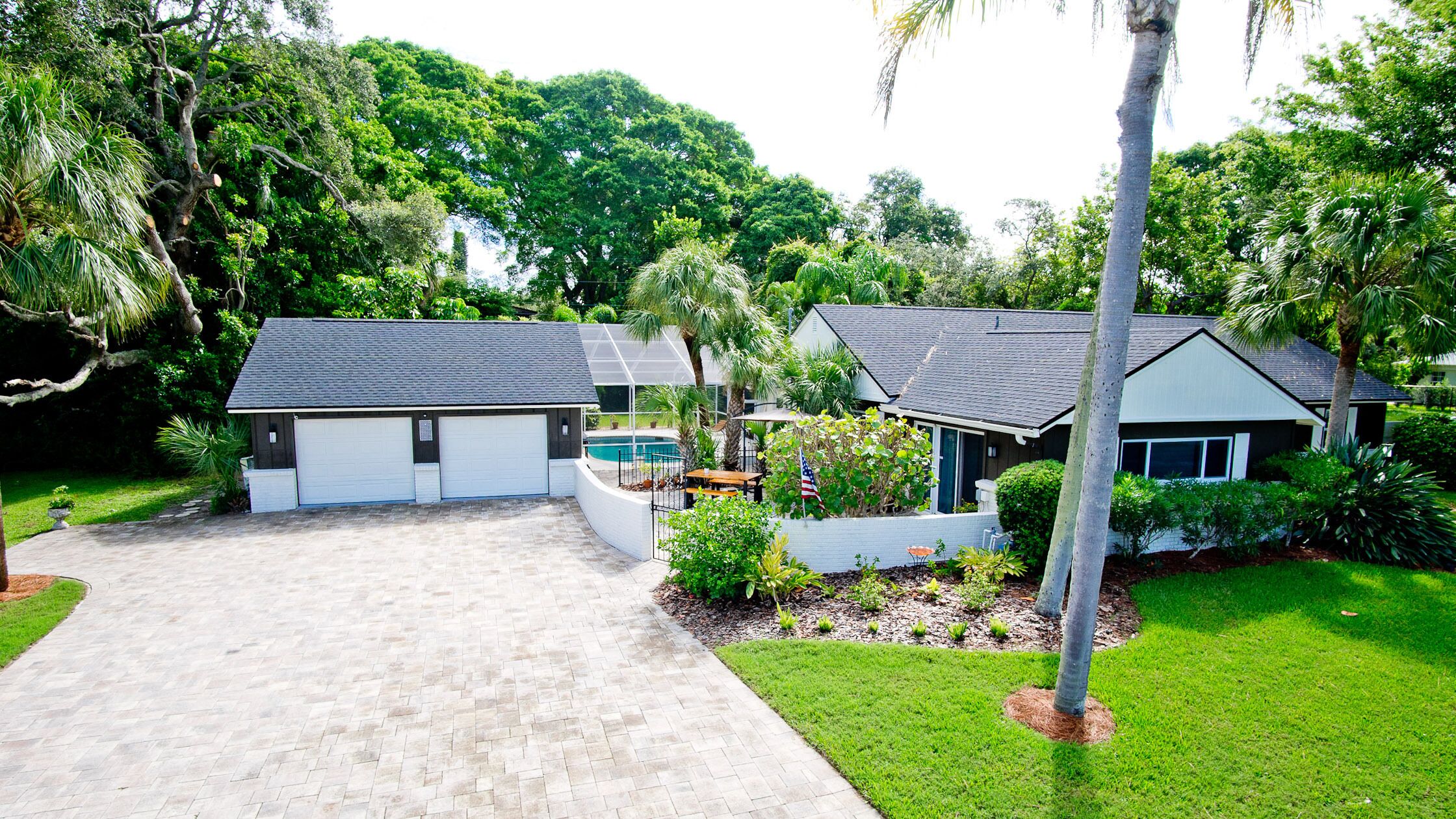 A residential property with a garage, a swimming pool, and a well-maintained lawn.