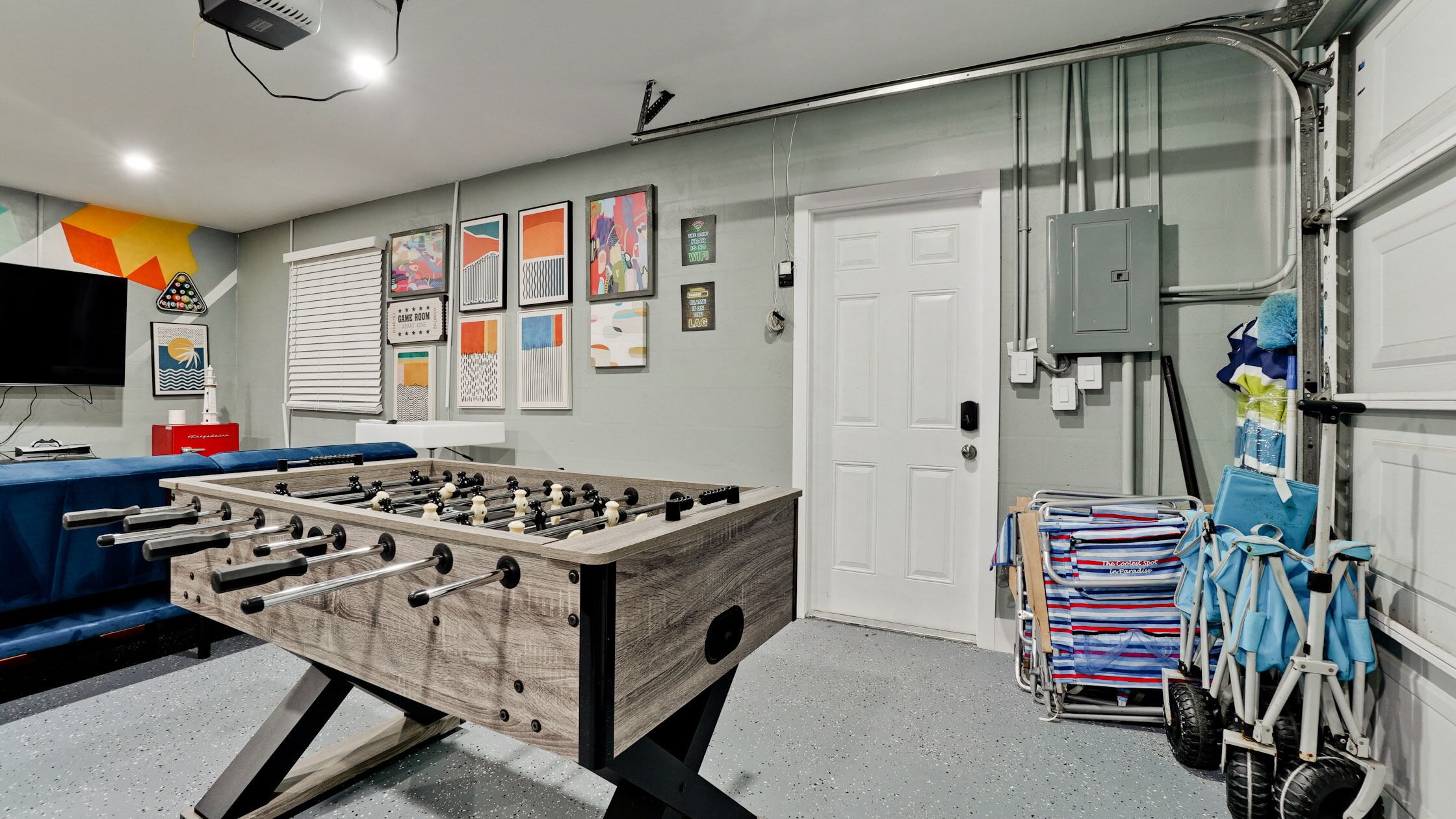 Ein Zimmer mit Tischfußball, Fernseher und einer Tür mit Sicherheitssystem.