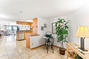 Enjoy a compact yet comfortable living space with a kitchen, dining area, and balcony offering a view of the outdoors.