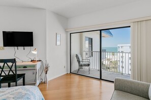 Enjoy ocean views from the balcony, featuring a sofa, chair, and flat-screen TV.