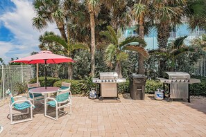 Enjoy al fresco dining on the patio, surrounded by lush greenery and equipped with a barbecue grill and comfortable seating.