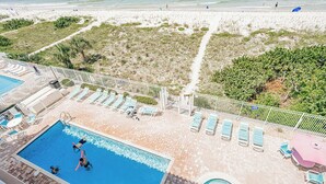 A rooftop pool area with multiple swimming pools, sun loungers, and a view of the beach. - Direct GULF front Condo - Oceanway 403 (Indian Rocks Beach)