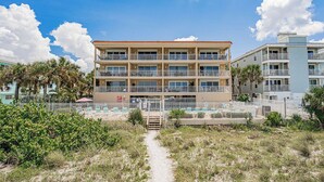 A multi-story hotel with a central courtyard, outdoor pool, and a beach view. - Direct GULF front Condo - Oceanway 403 (Indian Rocks Beach)