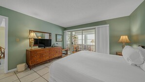Ein Hotelzimmer mit Bett, einem Holzschrank, einem Fernseher und einem Balkon mit Blick.