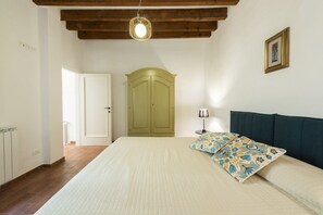 A bedroom with a bed, a wardrobe, a lamp, and a ceiling light.