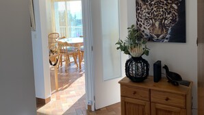 A room with a wooden cabinet, a leopard painting, and a woven ceiling light fixture. - Adorable T2 apartment (45m2) in a residence with panoramic sea view (Jard-sur-Mer)