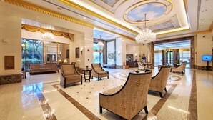 A spacious lobby with a chandelier, seating area, and a reception desk. - Royal Gardens Waikiki - Sleeps 3 Full Kitchen  (Honolulu)