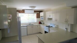 A kitchen with white cabinets, a built-in microwave, a stove, and a dishwasher.