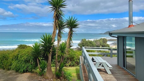 A modern building with a balcony overlooking a beach and ocean. - Surf Shack - Beach Front (Separation Creek)