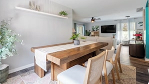 A dining area with a wooden table, chairs, and a ceiling fan. - Family Paradise: 5BR Kissimmee Home with Private Pool and Pet Friendly (Kissimmee)