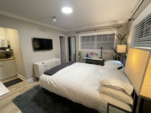 Cozy retreat with a comfortable bed, flat-screen TV, and workspace.