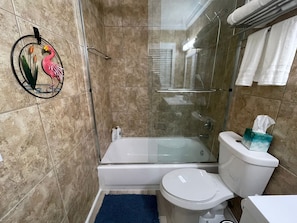Enjoy a refreshing shower in the bathroom, featuring a glass-enclosed shower, bathtub, and toilet.
